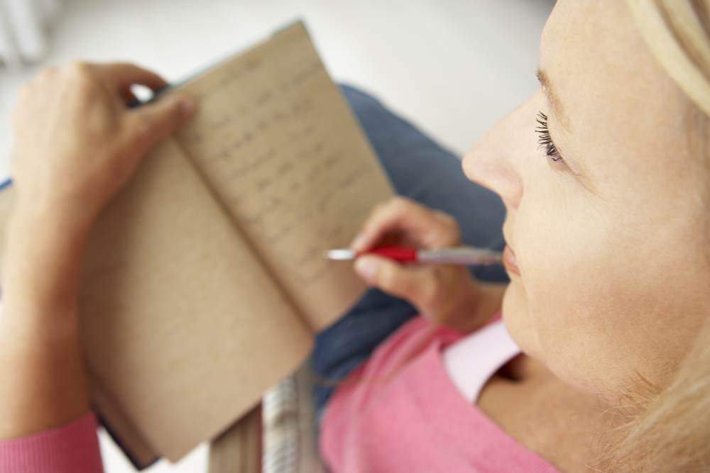 Senior woman writing in notebook